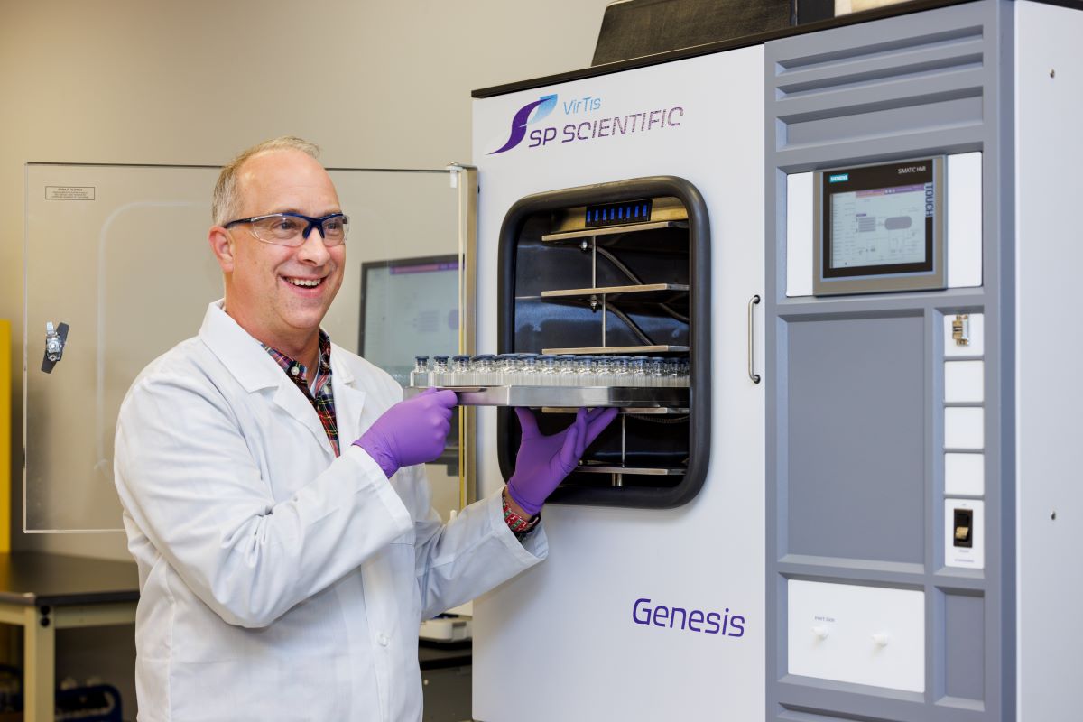 A scientist putting vials in an SP freeze dryer.