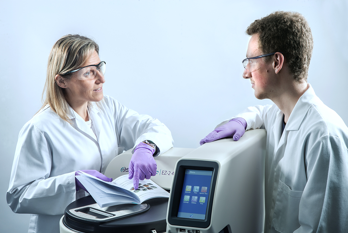Two scientists talking to each other over an SP product.